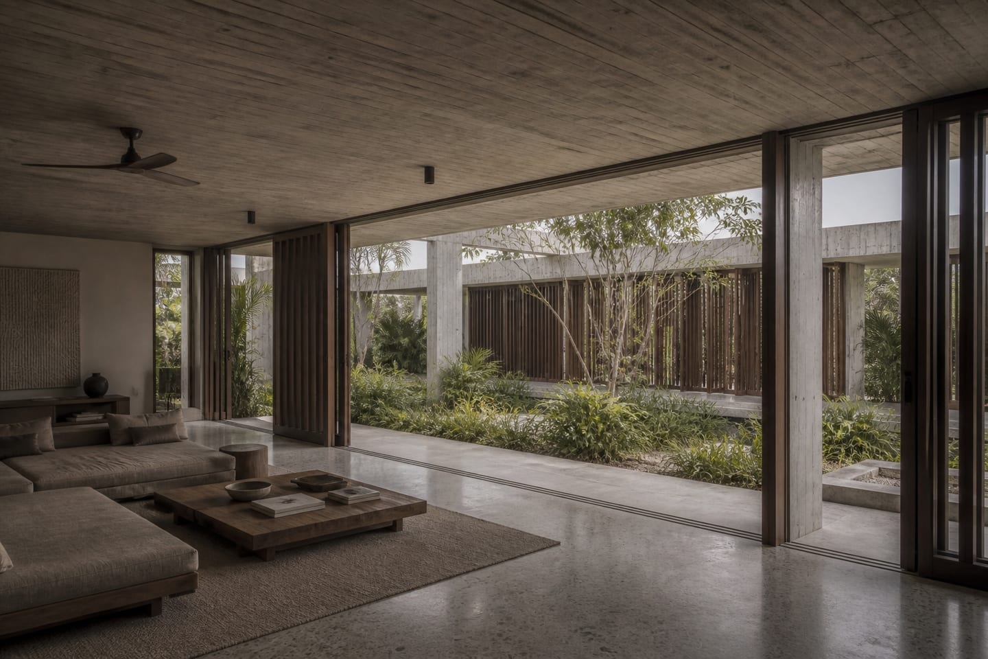 Indirect daylight moving from a planted rain court into a concrete living room