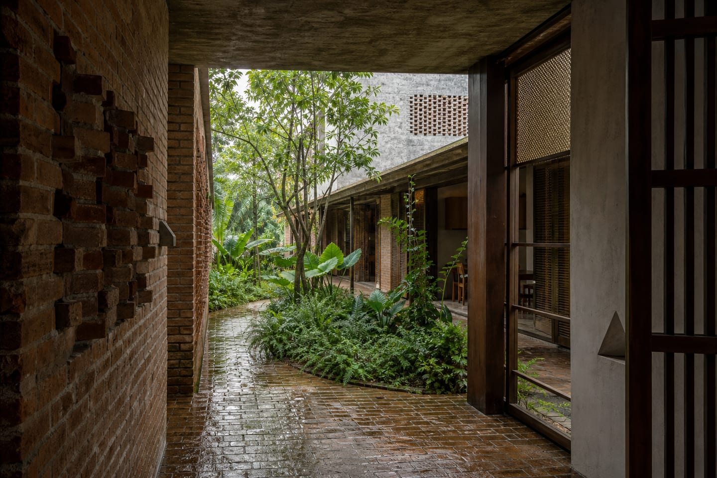Terracotta courtyard house wrapped around a lush garden after rain