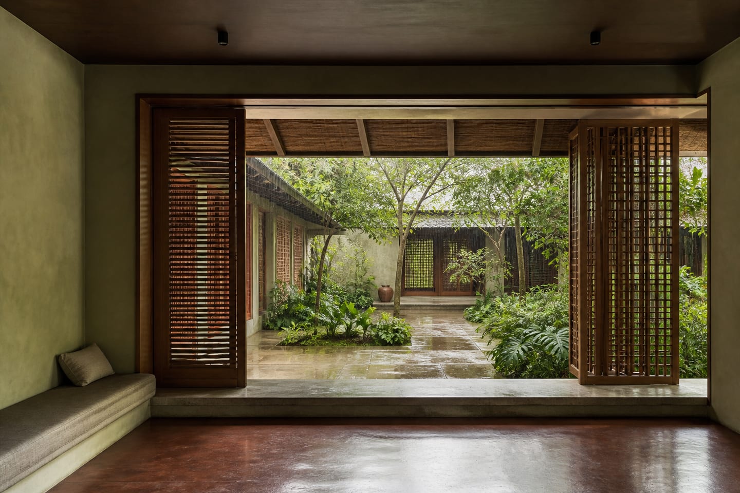 Covered tropical threshold opening from a quiet room into a rain-wet courtyard